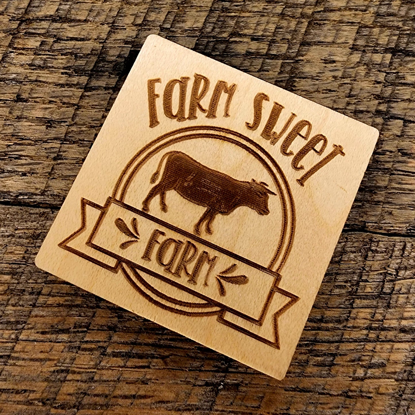 Magnet with inscription: "Farm Sweet Farm" and a cow tilted right