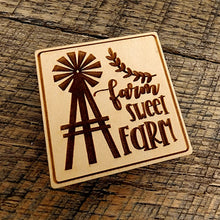 Load image into Gallery viewer, Magnet with &quot;Farm Sweet Farm&quot; printed on it. A windmill design to the left of the lettering and the magnet is tilted left
